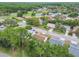 Overhead view showcasing a charming neighborhood with single-Gathering homes, mature trees, and winding streets near a serene pond at 13127 Topflite Ct, Hudson, FL 34669