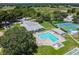 An aerial view of the community pool, tennis courts, and lush green landscape at 13127 Topflite Ct, Hudson, FL 34669