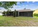 Spacious backyard featuring green lawn and a screened-in enclosure at 13127 Topflite Ct, Hudson, FL 34669