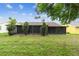 Spacious backyard featuring green lawn and a screened-in enclosure at 13127 Topflite Ct, Hudson, FL 34669