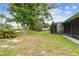 Lush backyard featuring mature trees, green grass, and a screened-in porch perfect for outdoor enjoyment and relaxation at 13127 Topflite Ct, Hudson, FL 34669