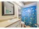 Bathroom with a blue fish-themed shower curtain, white vanity, and modern fixtures at 13127 Topflite Ct, Hudson, FL 34669