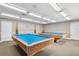 Billiard room with two pool tables, ample lighting, and neutral decor provides a relaxed atmosphere at 13127 Topflite Ct, Hudson, FL 34669