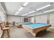 Billiard room showcasing two pool tables, cue racks, and seating with bright lighting at 13127 Topflite Ct, Hudson, FL 34669