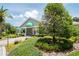 Inviting clubhouse exterior with lush landscaping, green awnings, and a welcoming entrance at 13127 Topflite Ct, Hudson, FL 34669