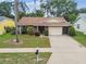 Attractive home boasts mature landscaping, a well-manicured lawn, and an attached garage, set in a desirable neighborhood at 13127 Topflite Ct, Hudson, FL 34669