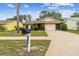 Charming home featuring a neatly maintained front lawn, mature trees, and traditional mailbox at 13127 Topflite Ct, Hudson, FL 34669