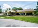 Exterior of the Meadow Oaks Golf & Country Club with brick accents and lush green grass at 13127 Topflite Ct, Hudson, FL 34669