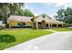 A beautiful front exterior of Meadow Oaks Golf & Country Club with a well-manicured lawn at 13127 Topflite Ct, Hudson, FL 34669