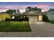 Charming single-story home with manicured lawn and attached two-car garage at twilight at 13127 Topflite Ct, Hudson, FL 34669