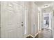 Bright hallway features a stylish front door, wood floors, and doors that lead to rooms at 13127 Topflite Ct, Hudson, FL 34669