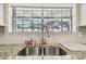Close-up view of the kitchen sink and window overlooking the backyard, showing the neighborhood beyond the property line at 13127 Topflite Ct, Hudson, FL 34669