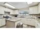 Bright kitchen features granite countertops, white cabinetry, stainless steel appliances, and an island for food preparation at 13127 Topflite Ct, Hudson, FL 34669