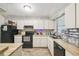 Efficient kitchen design with white cabinets and black appliances at 13127 Topflite Ct, Hudson, FL 34669