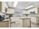 Bright, all-white kitchen featuring stainless appliances, granite counters, and an island at 13127 Topflite Ct, Hudson, FL 34669