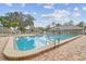 Large community pool featuring clean water and brick patio perfect for lounging on a beautiful sunny day at 13127 Topflite Ct, Hudson, FL 34669