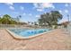 Full community pool area with a large pool, brick pavers, and palm trees, offering a serene and resort-like atmosphere at 13127 Topflite Ct, Hudson, FL 34669