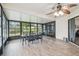 Enclosed sunroom featuring tile floors, ceiling fan, and large windows offering ample natural light and outdoor views at 13127 Topflite Ct, Hudson, FL 34669