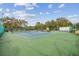 Community tennis courts with fencing, trees, blue skies, and a covered picnic table area perfect for enjoying outdoor activities at 13127 Topflite Ct, Hudson, FL 34669