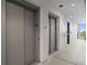 Hallway with two elevators featuring gray doors and a number five to show level number at 132 Mirror Lake N Dr # 501, St Petersburg, FL 33701
