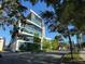 Modern building exterior, surrounded by lush greenery under a clear blue sky, promising a luxurious urban living experience at 132 Mirror Lake N Dr # 501, St Petersburg, FL 33701