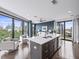 Modern kitchen with island and stainless steel appliances, seamlessly connected to the open-concept living area with cityscape views at 132 Mirror Lake N Dr # 501, St Petersburg, FL 33701