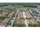 Aerial view of townhome community featuring a central pond, landscaped streets, and a mix of townhomes and single-Gathering homes at 13306 Wildgrass Trl, Odessa, FL 33556