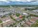 Aerial view of a townhome community close to commercial areas and major roadways, surrounded by green spaces and landscaping at 13306 Wildgrass Trl, Odessa, FL 33556