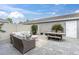 Cozy backyard patio with woven seating, a small outdoor table, and lush landscaping, perfect for relaxing and entertaining at 13306 Wildgrass Trl, Odessa, FL 33556