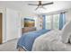 Bedroom features a ceiling fan, bright natural light, and flat screen television at 13306 Wildgrass Trl, Odessa, FL 33556