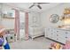 Bedroom features pink decor, crib, and changing table at 13306 Wildgrass Trl, Odessa, FL 33556