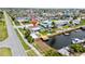 Scenic aerial view of a waterfront property with a private dock, surrounded by lush greenery and calm waters at 13715 Maria Dr, Hudson, FL 34667
