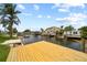 Waterfront backyard featuring a new dock, lush trees, and views of other waterfront homes at 13715 Maria Dr, Hudson, FL 34667