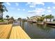 Waterfront backyard featuring a new dock, lush trees, and views of the neighborhood at 13715 Maria Dr, Hudson, FL 34667