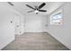 Bright bedroom with modern ceiling fan, grey flooring, and freshly painted white walls at 13715 Maria Dr, Hudson, FL 34667