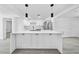 Modern kitchen featuring white cabinets, a large center island, and stainless steel appliances at 13715 Maria Dr, Hudson, FL 34667