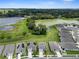 Aerial view of houses and pond surrounded by lush landscapes and blue skies at 13919 Wineberry Dr, Dade City, FL 33525