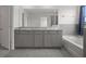 Bathroom featuring double sink vanity, granite countertops, and a separate tub at 13919 Wineberry Dr, Dade City, FL 33525