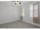 A bedroom with tile flooring, two windows with curtains, and a ceiling fan at 13919 Wineberry Dr, Dade City, FL 33525