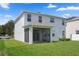 Two-story home showcasing a screened-in porch, a well-manicured lawn, and neutral exterior at 13919 Wineberry Dr, Dade City, FL 33525