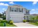 Light gray two-story home with a two-car garage, stone accents, and landscaped front yard at 13919 Wineberry Dr, Dade City, FL 33525