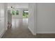 Open-concept foyer with tile flooring leading to the living area, and view of lake through windows at 13919 Wineberry Dr, Dade City, FL 33525