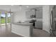 Modern kitchen with gray cabinets, granite countertops, a center island, and stainless steel appliances at 13919 Wineberry Dr, Dade City, FL 33525