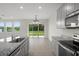 Open-concept kitchen with stainless steel appliances and backyard view at 13919 Wineberry Dr, Dade City, FL 33525