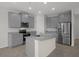 Spacious kitchen with stainless steel appliances and gray cabinets at 13919 Wineberry Dr, Dade City, FL 33525
