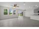 Open-concept living room with natural light, tile floors, and a view of the backyard and kitchen at 13919 Wineberry Dr, Dade City, FL 33525