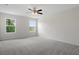 Comfortable main bedroom featuring carpet, two windows, and a ceiling fan at 13919 Wineberry Dr, Dade City, FL 33525