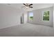 Bright main bedroom with carpet, ceiling fan, and picturesque windows showcasing outdoor views at 13919 Wineberry Dr, Dade City, FL 33525