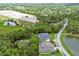 Overhead view of a property with manicured lawn and landscaping and neighboring lush wooded areas and farmland at 1460 Kensington Woods Dr, Lutz, FL 33549