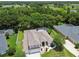 Bird's eye view of the property featuring mature landscaping, fenced yard, and proximity to a lake, and lush surroundings at 1460 Kensington Woods Dr, Lutz, FL 33549